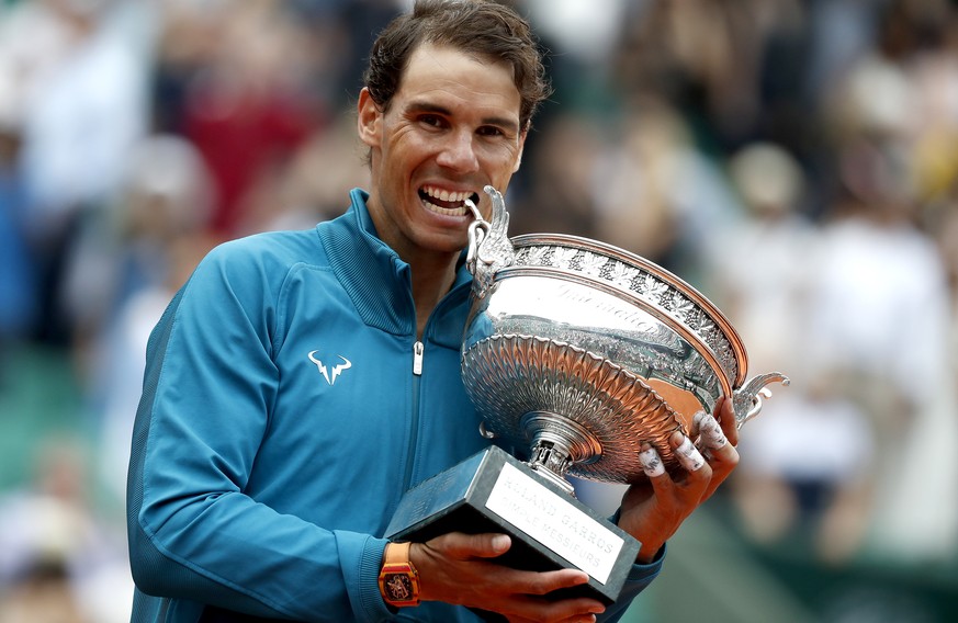 epa06799083 Rafael Nadal of Spain celebrates with the trophy after winning his 11th French Open title against Dominic Thiem of Austria during their men’s final match during the French Open tennis tour ...
