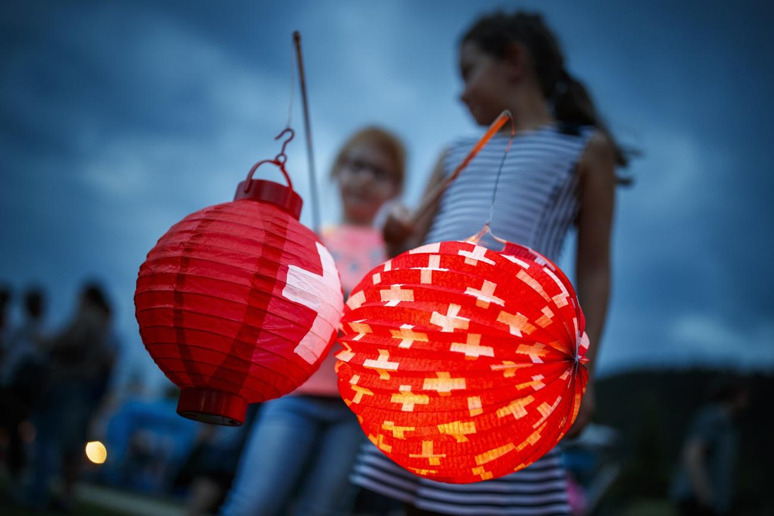 Des enfants jouent avec des lampions decores de la croix suisse lors de la fete nationale du Val-de-Travers ce lundi 31 juillet 2017 a Motiers. (KEYSTONE/Valentin Flauraud)