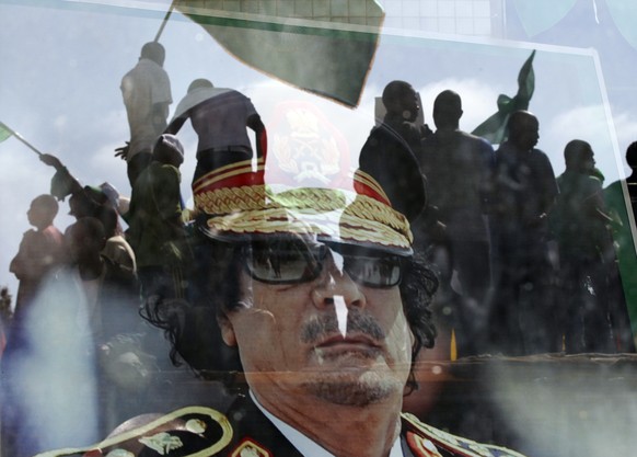 ZUM 5. JAHRESTAG DES AUSBRUCHS DES ARABISCHEN FRÜHLINGS IM DEZEMBER 2015 STELLEN WIR IHNEN FOLGENDES BILDMATERIAL ZUR VERFUEGUNG - Moammar Gadhafi&#039;s portrait is seen behind the window as people f ...