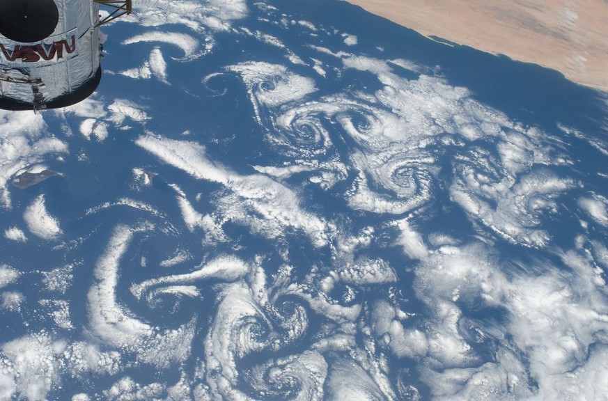 In this image provided by NASA low-level winds rushing over the Cape Verde Islands off the coast of northwestern Africa created cloud vortexs which share this scene with the top of the Hubble Space Te ...