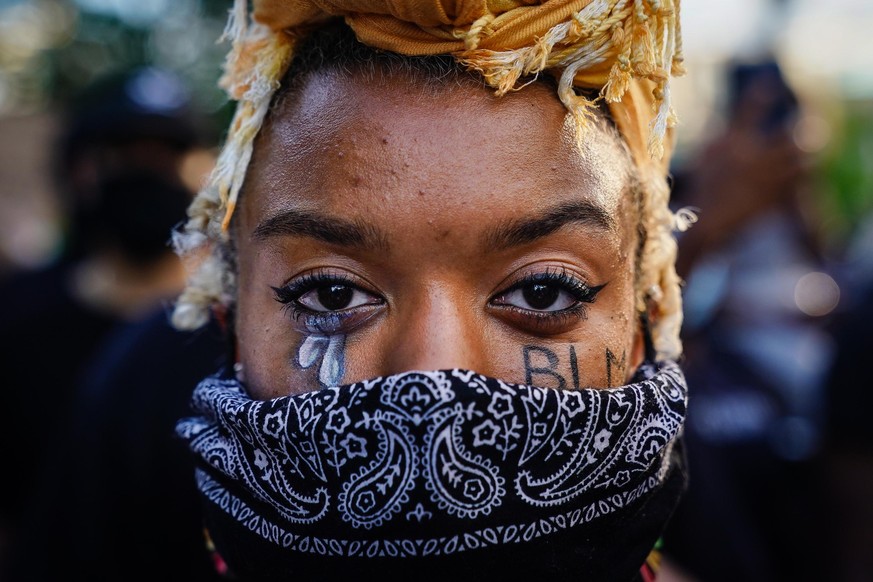 ATLANTA, GA - MAY 31: A woman with &#039;BLM&#039; written on her cheek poses for a picture during a demonstration on May 31, 2020 in Atlanta, Georgia. Across the country, protests have erupted follow ...