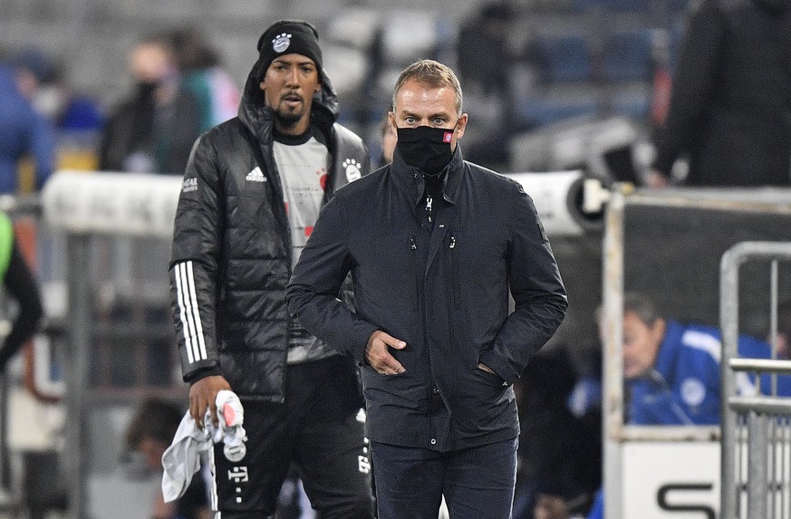 Bayern&#039;s head coach Hans-Dieter Flick watches from the side in front of Jerome Boateng, behind, during the German Bundesliga soccer match between Arminia Bielefeld and Bayern Munich in Bielefeld, ...