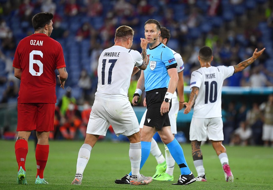 epa09263231 Ciro Immobile (2-L) of Italy argues with Dutch referee Danny Makkelie (C) during the UEFA EURO 2020 group A preliminary round soccer match between Turkey and Italy at the Olympic Stadium i ...