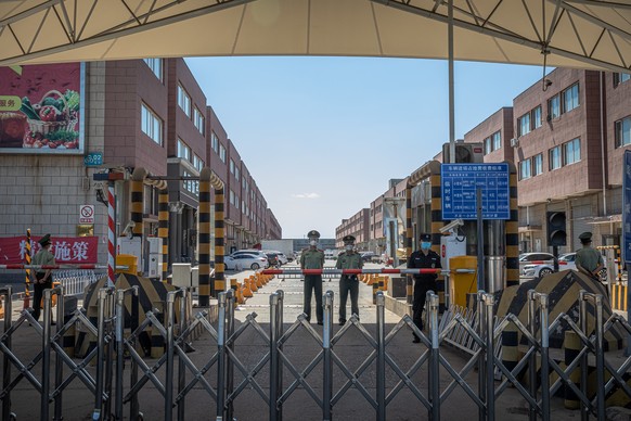 epa08484491 Paramilitary police officers and security staff wearing protective face masks stand guard next to the closed Xinfadi market, in Fengtai district, Beijing, China, 14 June 2020. One of Beiji ...