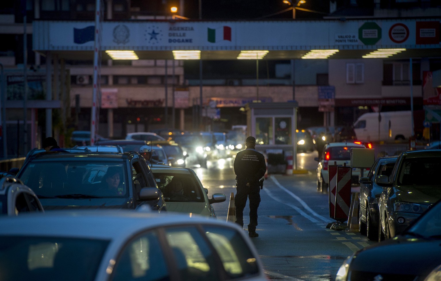 Fahrzeuge mit italienischen Kennzeichen stauen sich am Dienstag abend, 4. Februar 2014, auf ihrem Weg in die Schweiz vor dem Grenzuebergang in Ponte Tresa TI. (KEYSTONE/Ti-Press/Gabriele Putzu)