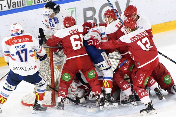 Les joueurs lausannois, rouge, et les joueurs zuerichois, blanc, se bousculent dans un goal lors de la rencontre du championnat suisse de hockey sur glace de National League entre le Lausanne Hockey C ...