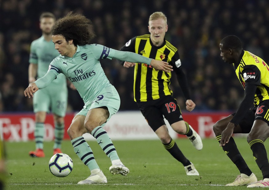 Arsenal&#039;s Matteo Guendouzi controls the ball in front of Watford&#039;s Will Hughes and Abdoulaye Doucoure, right, during the English Premier League soccer match between Watford and Arsenal at Vi ...