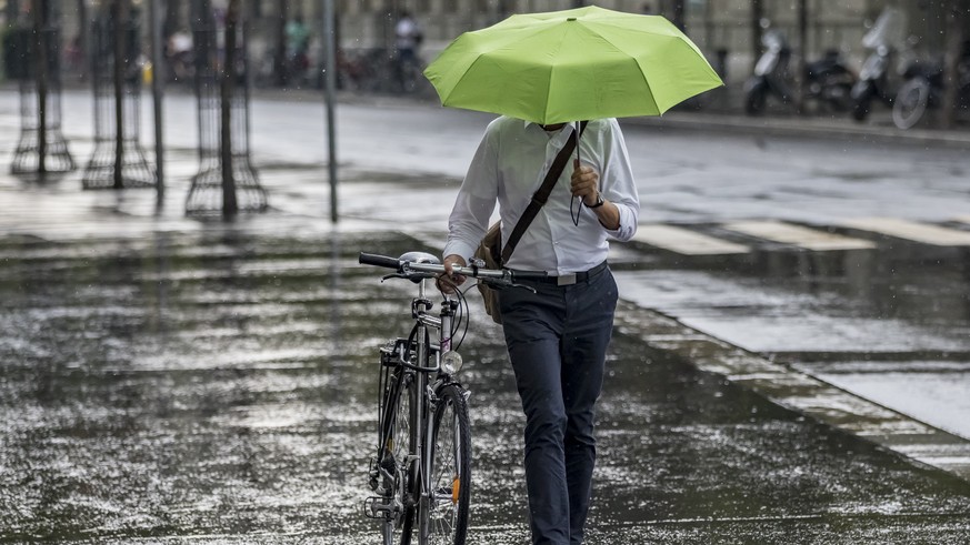 Ein Mann mit einem Schirm laeuft im Regen in Bern, am Mittwoch, 8. August 2018. (KEYSTONE/Thomas Hodel)