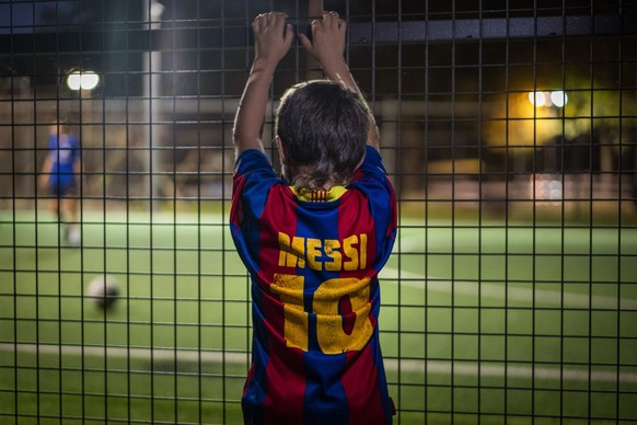 A boy wearing a shirt with the name of Barcelona soccer player Lionel Messi looks at at a soccer match in Banyoles, in Girona province, Spain on Wednesday, Sept. 2, 2020. Lionel Messi&#039;s future at ...
