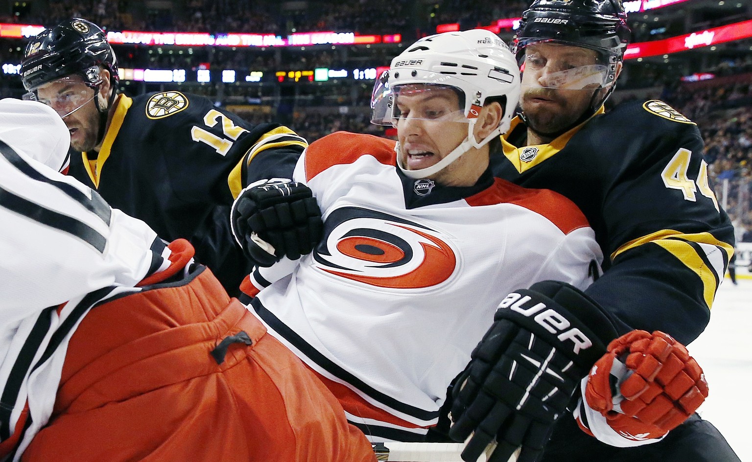 Carolina Hurricanes&#039; Zach Boychuk, second from right, and Boston Bruins&#039; Dennis Seidenberg (44), of Germany, battle for the puck during the first period of an NHL hockey game in Boston, Satu ...