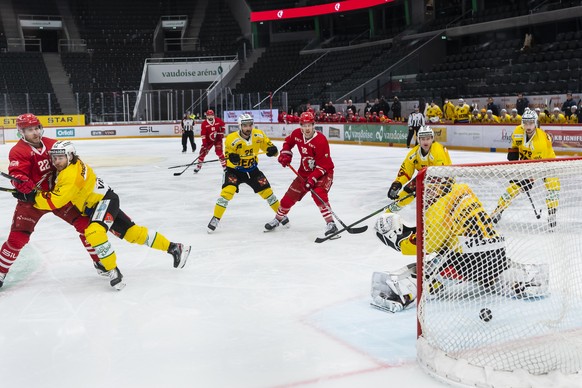 Le defenseur lausannois Lukas Frick, marque le premier but au gardien bernois Tomi Karhunen, droite, lors du match du championnat suisse de hockey sur glace de National League entre le Lausanne HC, LH ...