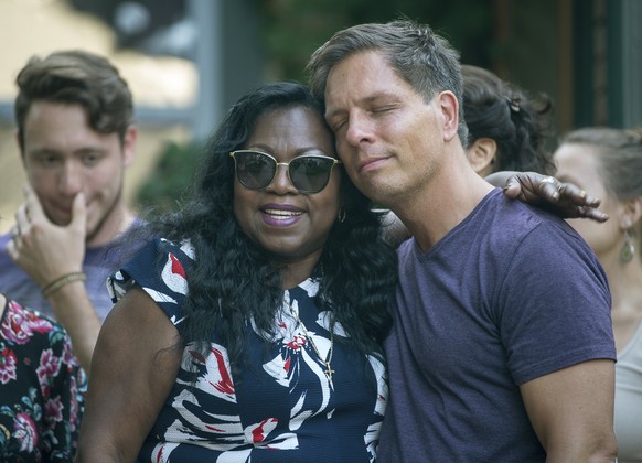 Don Damond, the fiance of Justine Damond, is comforted outside his home by Valerie Castile, the mother of Philando Castile, as demonstrators march by Damond&#039;s home during the Peace and Justice Ma ...