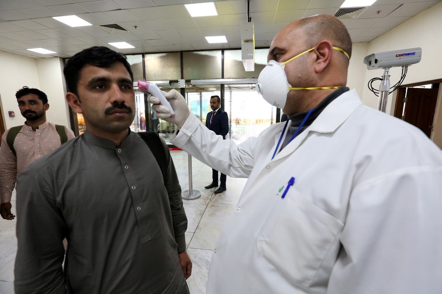 epa08244227 Members of Iraqi medical team check passengers upon arrival from Iran at Baghdad international airport in Baghdad, Iraq, 24 February 2020. According to reports, Iraqi health authorities sa ...