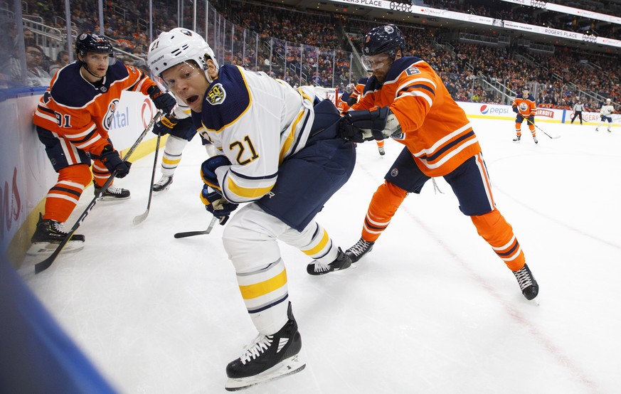 Buffalo Sabres&#039; Kyle Okposo (21) battles in the corner with Edmonton Oilers&#039; Adam Larsson (6) and Gaetan Haas (91)during the first period of an NHL hockey game, Sunday, Dec. 8, 2019 in Edmon ...