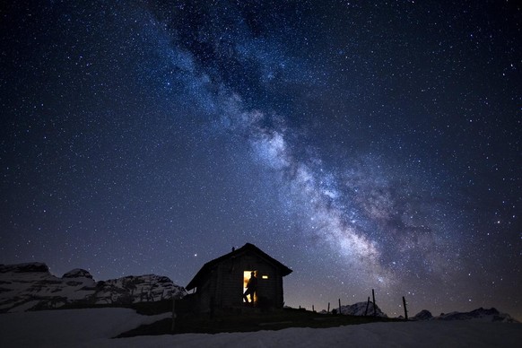 A man looks a beautiful starry sky with the milky way early morning from a little cabin at the Ormont Valley, Switzerland, Friday, May 18, 2018. (KEYSTONE/Anthony Anex)