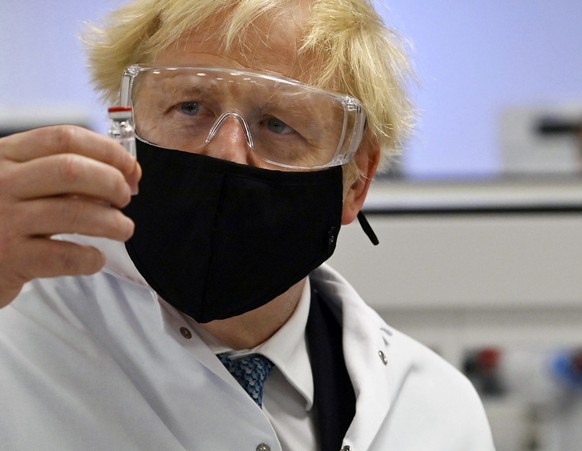 Britain&#039;s Prime Minister Boris Johnson holds a vial of the Oxford/AstraZeneca vaccine Covid-19 candidate vaccine, known as AZD1222, at Wockhardt&#039;s pharmaceutical manufacturing facility in Wr ...