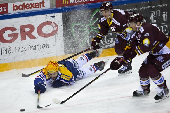 PostFinance Top Scorer Lions&#039; forward Denis Hollenstein, left, vies for the puck with Geneve-Servette&#039;s players forward Timothy Kast, center, and defender Arnaud Jacquemet, right, during a N ...