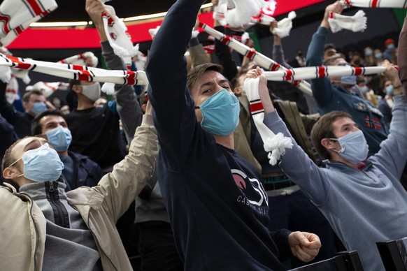 Lausanne&#039;s supporters wearing a protective face masks against the spread of the coronavirus COVID-19 cheer their players, during a National League regular season game of the Swiss Championship be ...