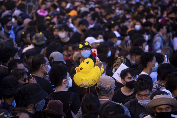 Inflatable yellow ducks, which have become a good-humored symbol of resistance during anti-government rallies, are held by a protester during a rally Wednesday, Nov. 25, 2020 in Bangkok, Thailand. Pro ...
