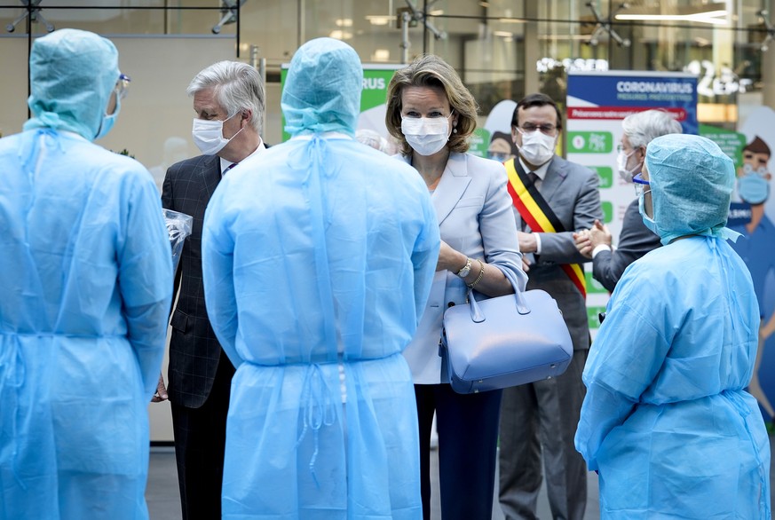 Belgium&#039;s King Philippe, second left, and Queen Mathilde, second right, speak to medical staff while visiting the Regional Hospital Center in Liege, Belgium, during the outbreak of the COVID-19 v ...