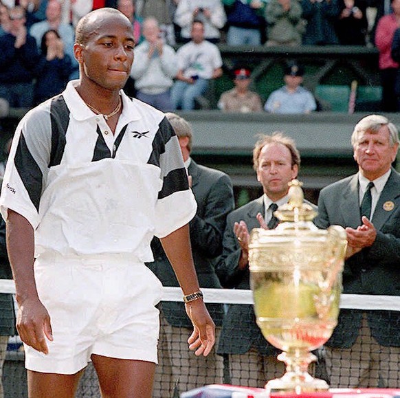 WIM22C-19960707-WIMBLEDON, United Kingdom: US MaliVai Washington looks at the Cup after his defeat against unseeded Richard Krajicek of the Netherlands in three sets 6-3, 6-4 and 6-3 in the Men&#039;s ...