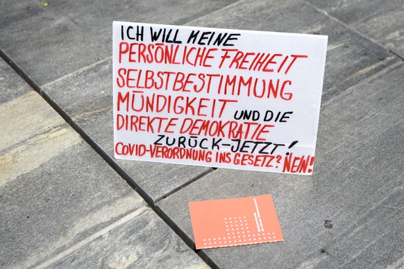 Ein Plakat fotografiert neben die Schweizerische Bundesverfassung auf dem Bundesplatz waehrend einer Demonstration gegen Massnahmen des Bundes im Zusammenhang mit dem Coronavirus, am Samstag, 27. Juni ...