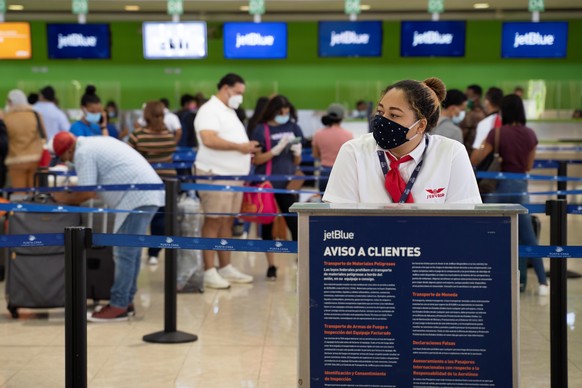 epa08521705 Travelers are served by workers of the Punta Cana International Airport, in Punta Cana, Dominican Republic, on 01 July 2020, after the Dominican authorities issued the protocol of tourist  ...