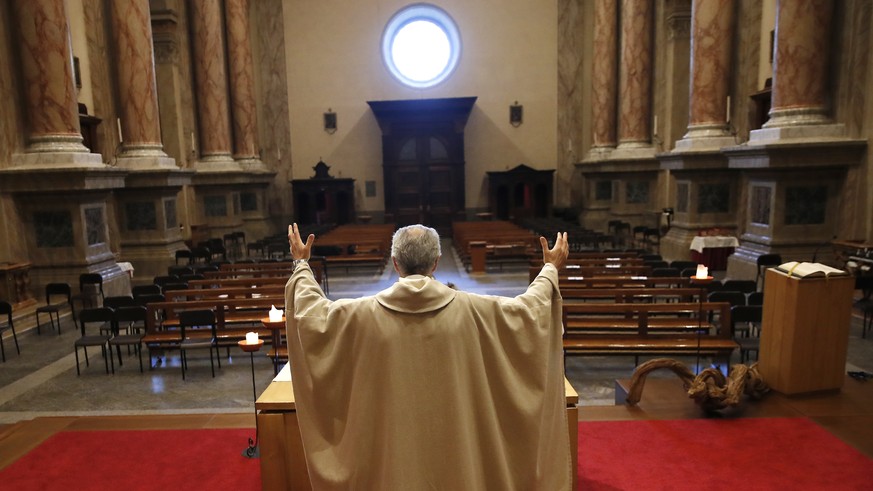 Don Angelo Riva celebrates a mass in an empty church after Italy&#039;s lockdown measure to prevent the spread of Covid-19, in Carenno, Italy, Thursday, April 2, 2020. The new coronavirus causes mild  ...
