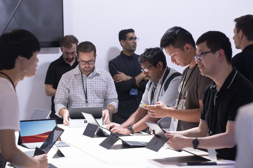People try the Microsoft Surface Pro X, Wednesday, Oct. 2, 2019 in New York. (AP Photo/Mark Lennihan)