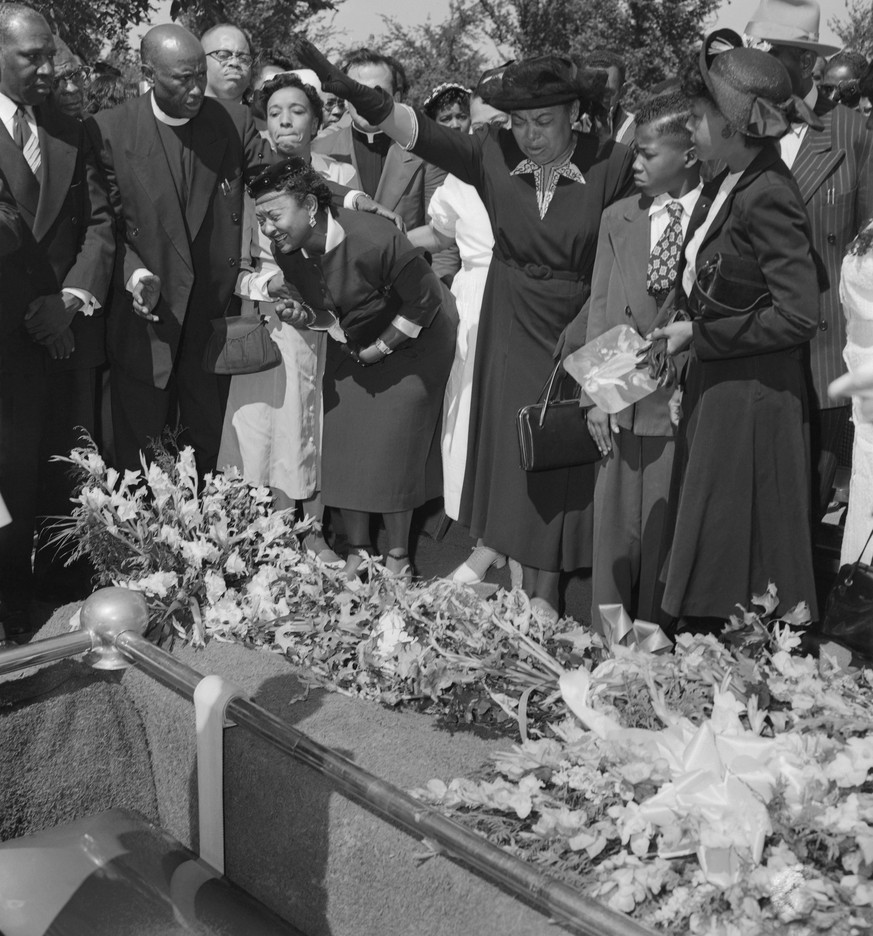(Original Caption) Friends restrain grief-stricken Mrs. Mamie Bradley (left) as her son&#039;s body is lowered into the grave after a four day, open casket funeral. The 15-year old Negro youngster, Em ...