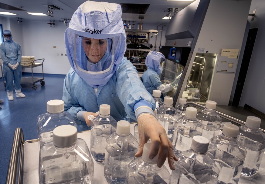 FILE - In this March 27, 2021 file photo a laboratory worker simulates the workflow in a cleanroom of the BioNTech Corona vaccine production in Marburg, Germany, during a media day. Ugur Sahin, BioNTe ...