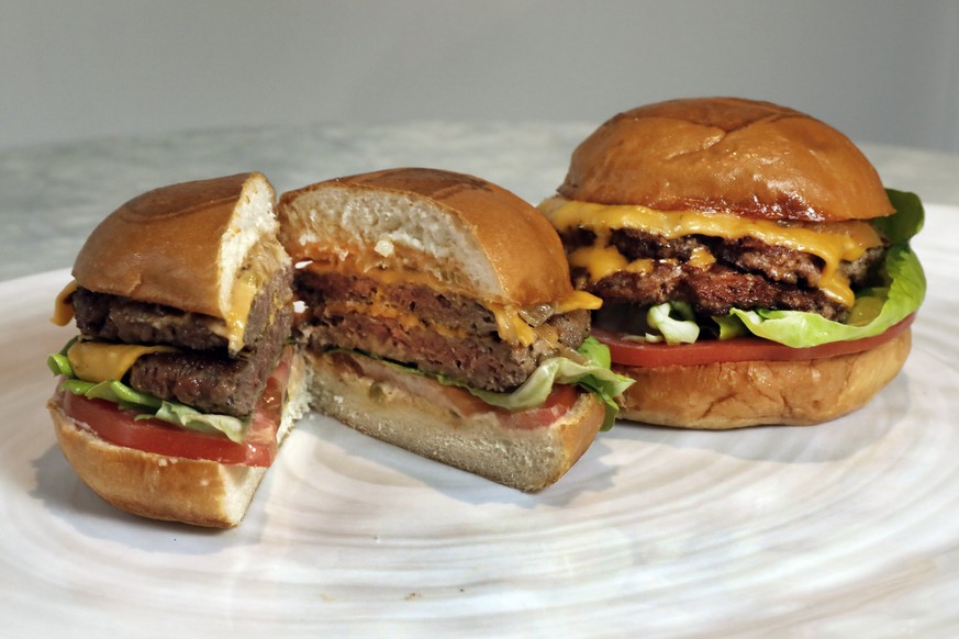 An Original Impossible Burger, left, and a Cali Burger, from Umami Burger, are shown in this photo in New York, Friday, May 3, 2019. A new era of meat alternatives is here, with Beyond Meat becoming t ...