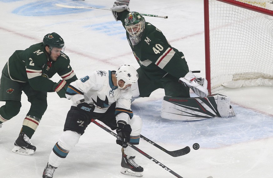 San Jose Sharks&#039; Micheal Haley, center, tries to position for a pass as Minnesota Wild&#039;s Anthony Bitetto, left, and goalie Devan Dubnyk defend in the first period of an NHL hockey game Monda ...