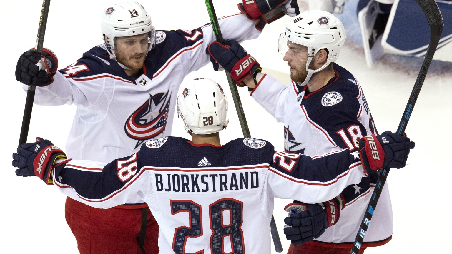 Columbus Blue Jackets right wing Oliver Bjorkstrand (28) is congratulated by teammates Gustav Nyquist (14) and Pierre-Luc Dubois (18) after scoring against the Tampa Bay Lightning during first-period  ...