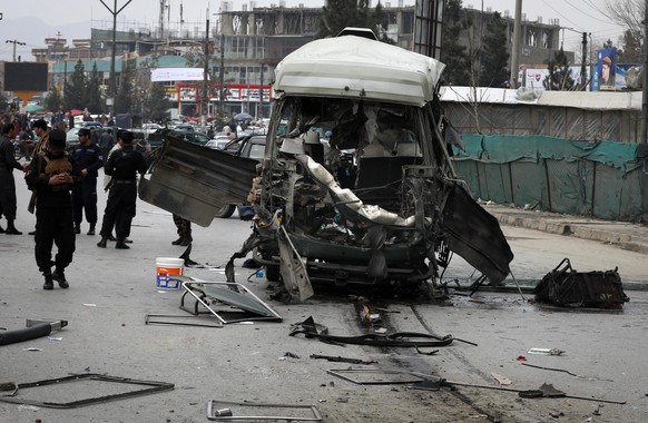 epa09076323 Afghan security officials inspect the scene of a bomb blast in Kabul, Afghanistan, 15 March 2021. At least 15 people were wounded when an explosion targeted a bus carrying the employees of ...