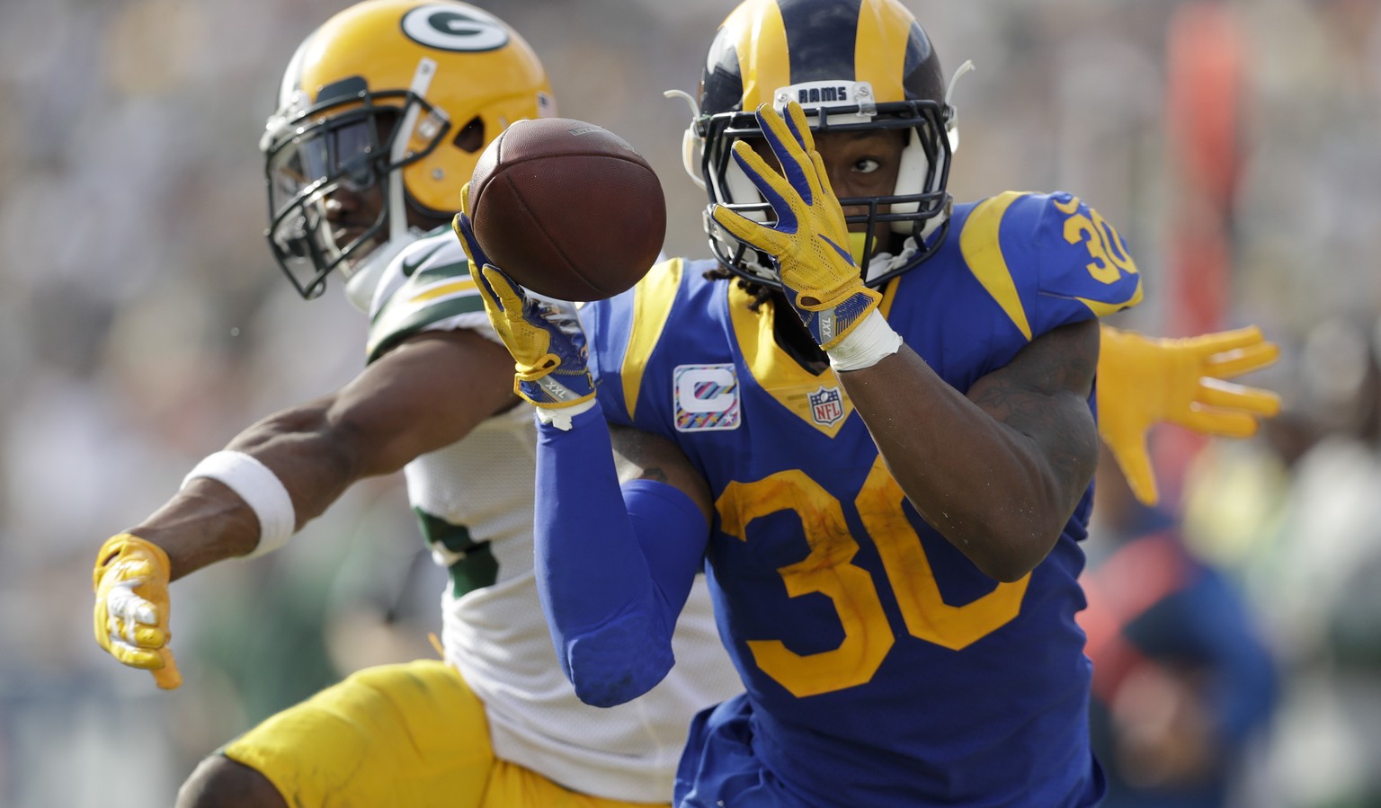 Los Angeles Rams running back Todd Gurley makes a catch as Green Bay Packers defensive back Jermaine Whitehead defends during the first half of an NFL football game, Sunday, Oct. 28, 2018, in Los Ange ...