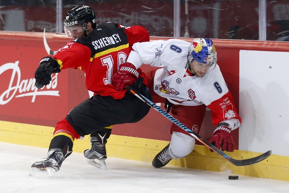 Bern&#039;s Tristan Scherwey, left, fights for the puck with Salzburg&#039;s Alexander Pallestrang during a Champions Hockey League round of 32, 2nd leg match between SC Bern of Switzerland and Red Bu ...