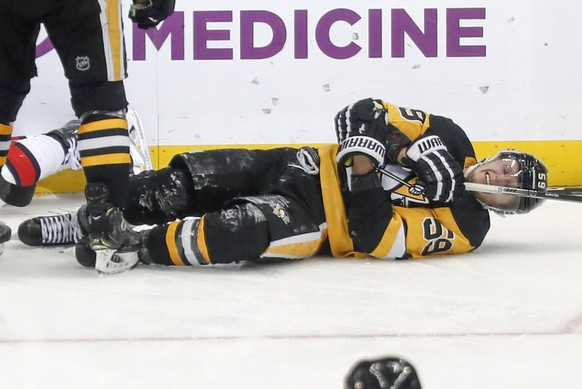 Pittsburgh Penguins&#039; Jake Guentzel (59) rolls on the ice after being injured after scoring a goal against the Ottawa Senators during the third period of an NHL hockey game, Monday, Dec. 30, 2019, ...