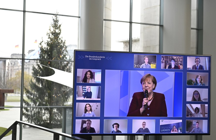 epa08884664 German Chancellor Angela Merkel is displayed on a giant screen as she holds an online dialogue with students, at the Chancellery in Berlin, Germany, 15 December 2020. EPA/TOBIAS SCHWARZ /  ...