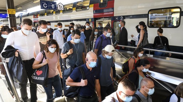 People wearing protective mask get out a SBB CFF train during the coronavirus disease (COVID-19) outbreak, at the train station CFF in Lausanne, Switzerland, Monday, July 6, 2020. In Switzerland, from ...