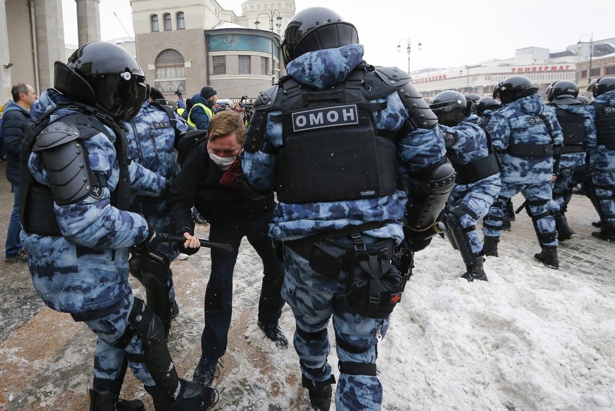 Police officers detain a man during a protest against the jailing of opposition leader Alexei Navalny in Moscow, Russia, Sunday, Jan. 31, 2021. Thousands of people took to the streets Sunday across Ru ...