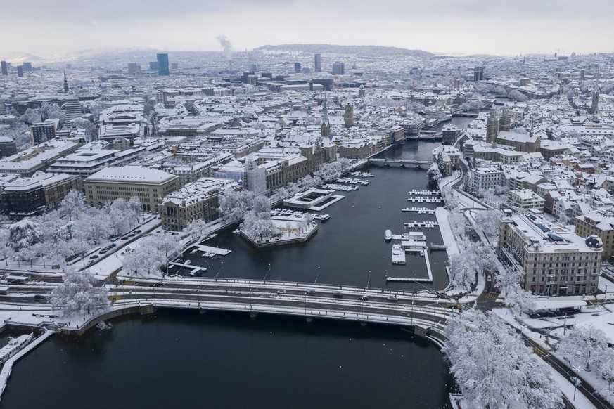 epa08939262 View of the inner-city of Zurich with the river Limmat and the Grossmuenster church (R), in Zurich, Switzerland, 15 January 2021. Record-breaking amounts of fresh snow have fallen in parts ...