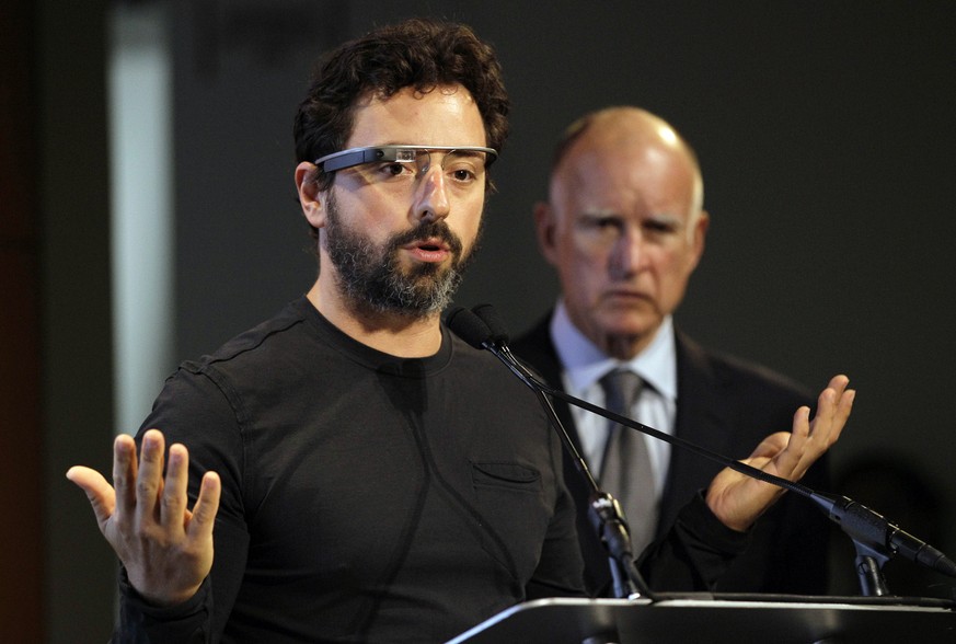FILE - In this Sept. 25, 2012 file photo, Google co-founder Sergey Brin, left, wearing Google Glass, speaks as California Gov. Jerry Brown, right, listens during a bill signing for driverless cars at  ...