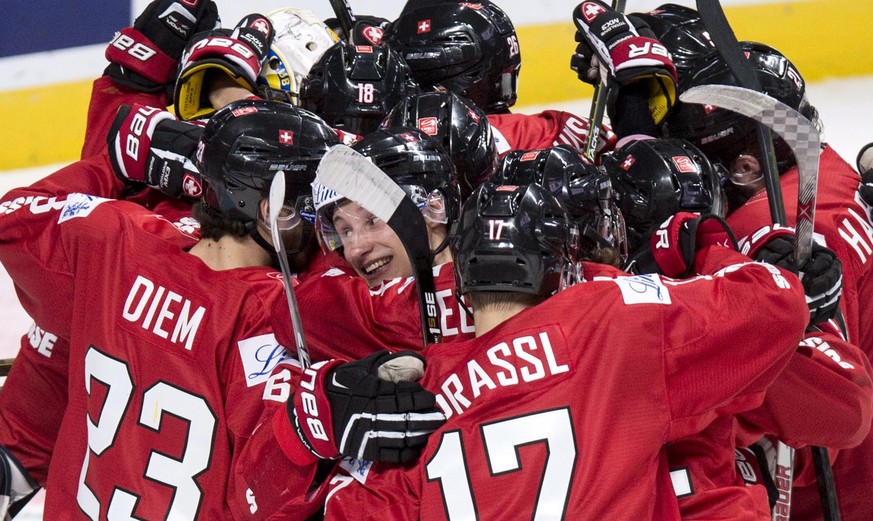 Switzerland&#039;s Loic In Albon, center, is surrounded by teammates as they celebrate their 5-4 victory over Denmark in the shootout of a World Junior hockey tournament game Friday, Dec. 30, 2016 in  ...