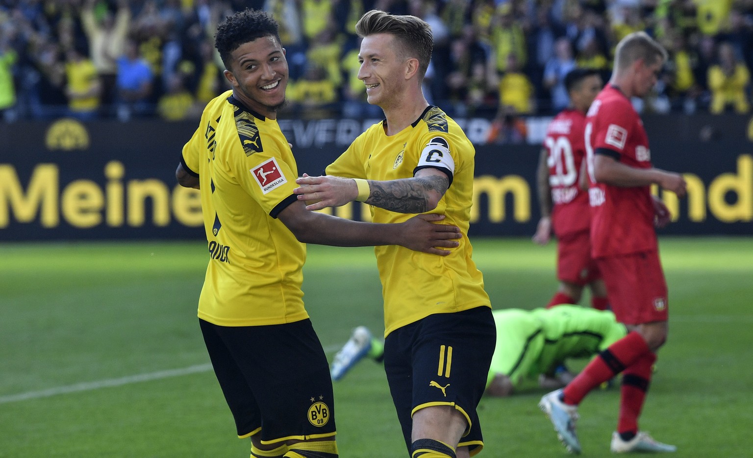 Dortmund&#039;s scorer Marco Reus, center, celebrates with Dortmund&#039;s Jadon Sancho, left, after he scored his side&#039;s second goal during the German Bundesliga soccer match between Borussia Do ...