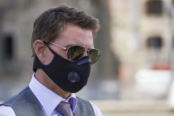 FILE - In this Tuesday, Oct. 13, 2020 file photo, actor Tom Cruise wears a face mask to prevent the spread of COVID-19 as he greets fans during a break from shooting Mission Impossible 7, along Rome&# ...