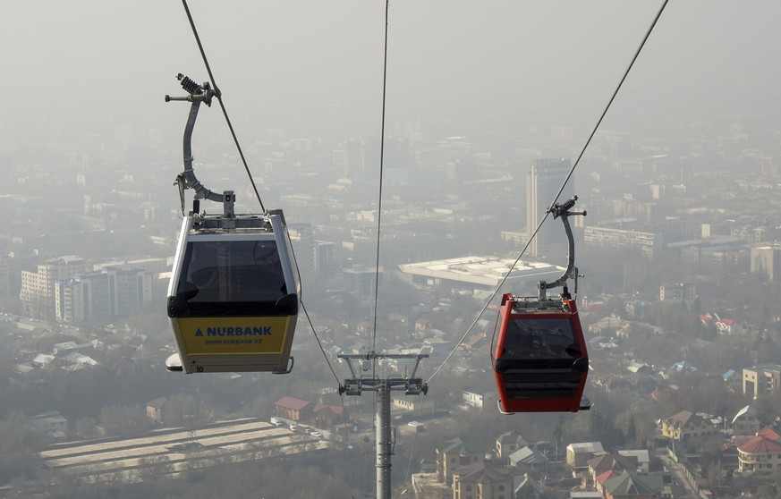 Cable cars are seen against the backdrop of downtown shrouded in smog in Almaty, Kazakhstan, March 4, 2016. REUTERS/Shamil Zhumatov
