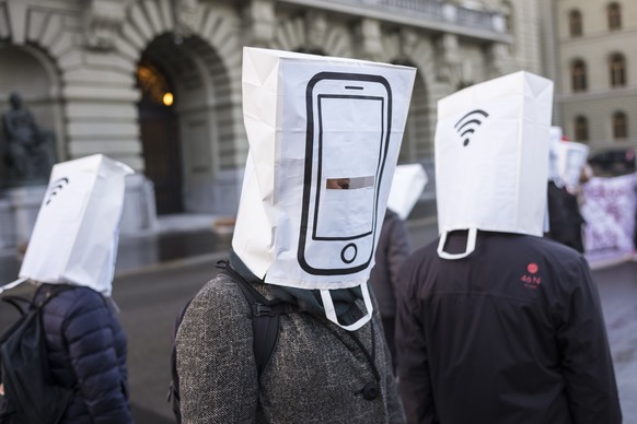 AktivistInnen warnen mit Masken, welche Mobiltelefone darstellen, gegen den Ausbau des Mobilfunknetzes auf den 5G Standard, am Rand der Fruehlingssession der Eidgenoessischen Raete, am Dienstag, 5. Ma ...
