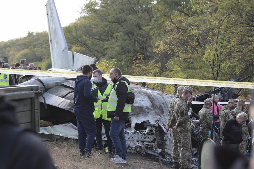 epa08698267 Rescuers inspect the crash site of the An-26 plane near of Chuguev city of Kharkiv&#039;s area, Ukraine, 26 September 2020. The An-26 plane of the Ukrainian Air Force crashed while landing ...