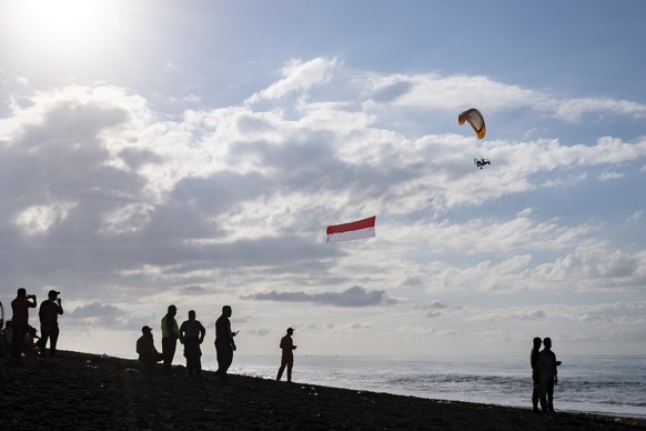 epa08608375 A powered paraglider carries an Indonesian flag during the 75th Independence Day celebration in Gianyar, Bali, Indonesia, 17 August 2020. Indonesia gained independence from the Netherlands ...